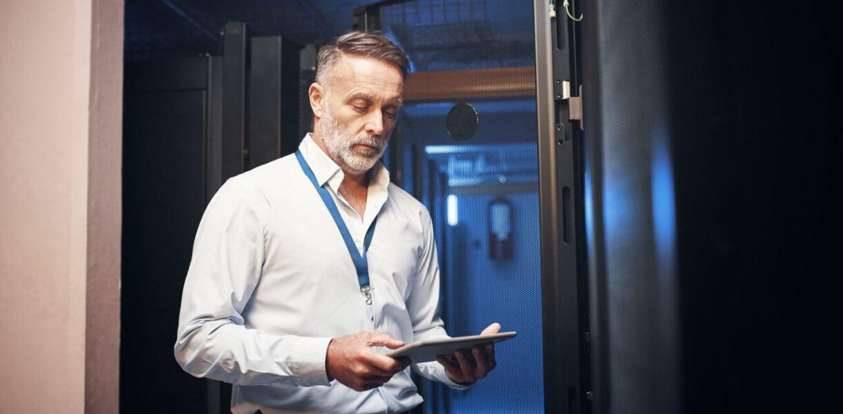 Technicien installant des équipements réseau dans une baie informatique d’entreprise